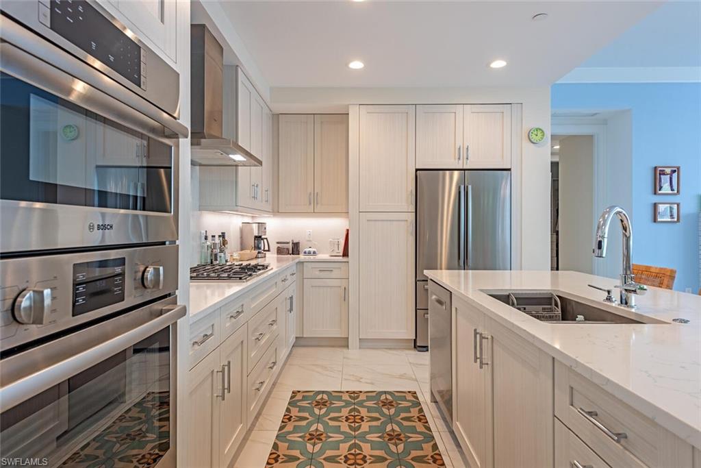 1135 3rd Avenue South, Unit 308 Naples, FL 34102 - Photo 7 of 18 a kitchen with stainless steel appliances granite countertop a refrigerator and a sink