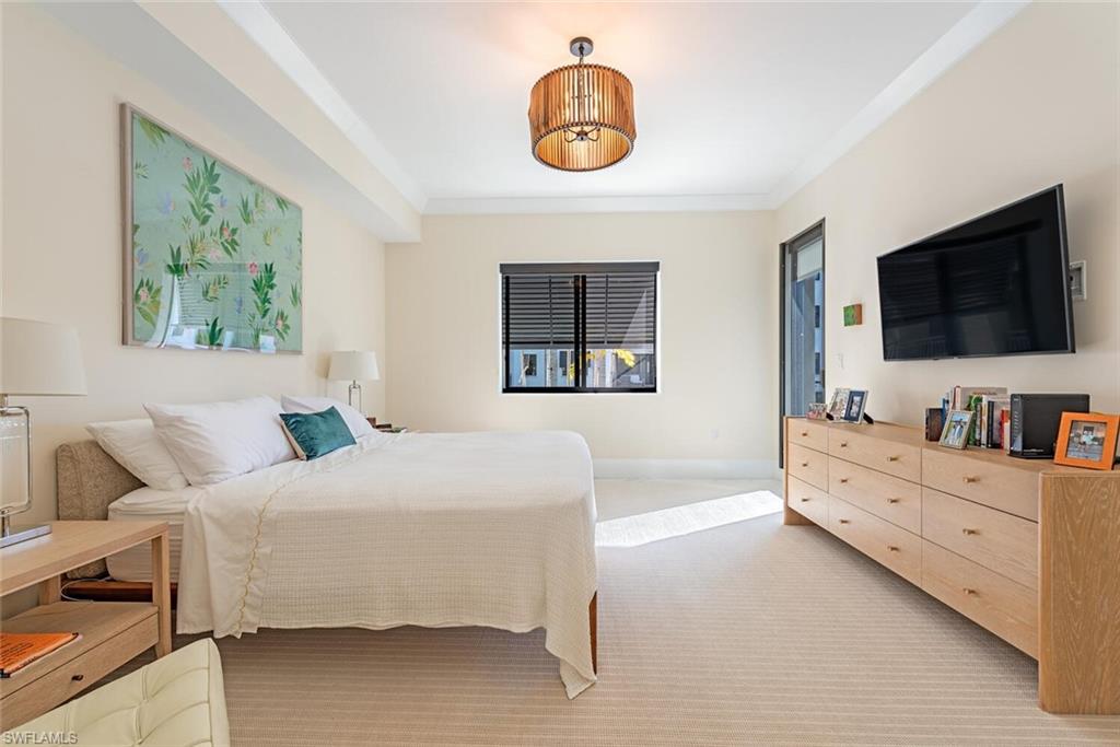 1135 3rd Avenue South, Unit 308 Naples, FL 34102 - Photo 10 of 18 a bedroom with a bed and a flat screen tv