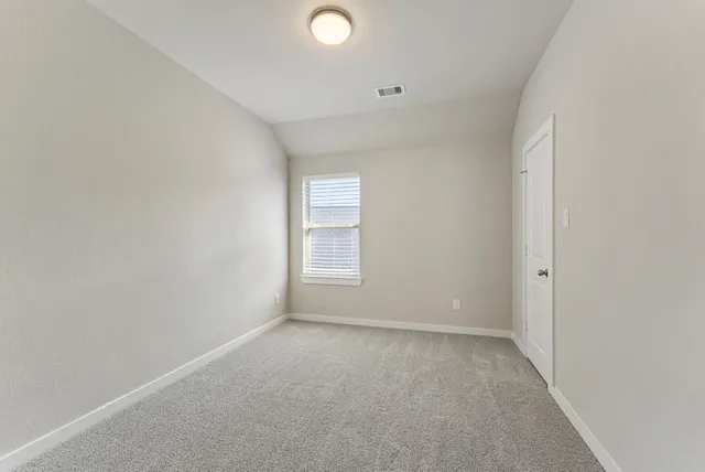 an empty room with window and ceiling fan