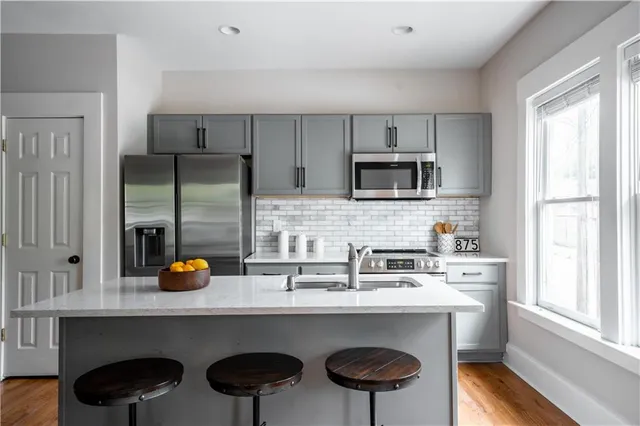 a kitchen with a sink a microwave a stove and cabinets