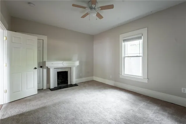 an empty room with fireplace and fan