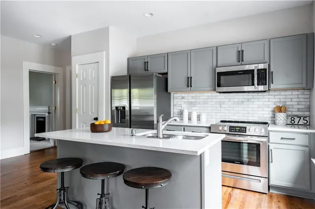 a kitchen with stainless steel appliances a stove a sink a microwave and cabinets