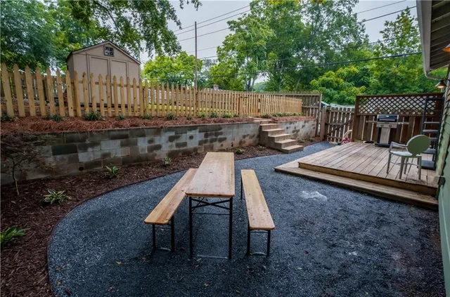 a view of backyard with deck and outdoor seating