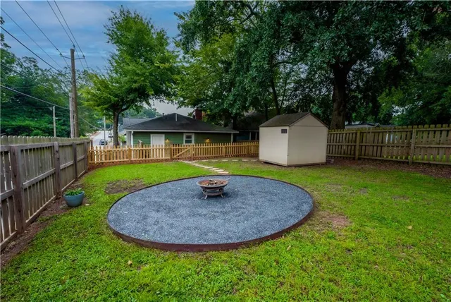 a view of a backyard with a small cabin and wooden fence