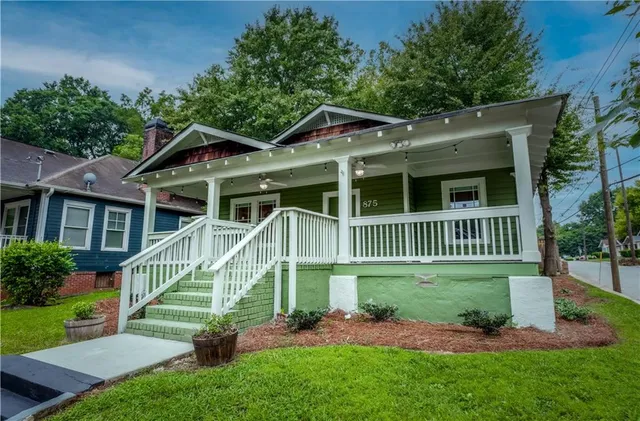a view of a house with a yard and potted plants