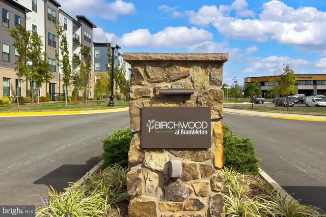 a living room with couches and a dining table with garden view