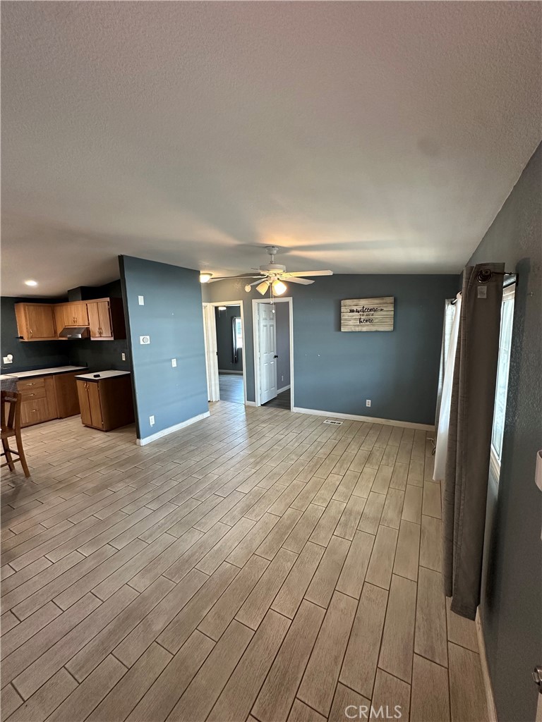 3825 Crestmore Road, Unit 414 Riverside, CA 92509 - Photo 9 of 31 an empty room with kitchen view and wooden floor