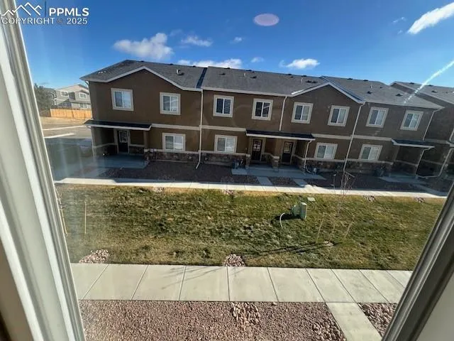a view of a big house with wooden fence