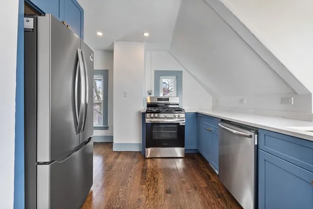 a kitchen with granite countertop a refrigerator and a stove top oven