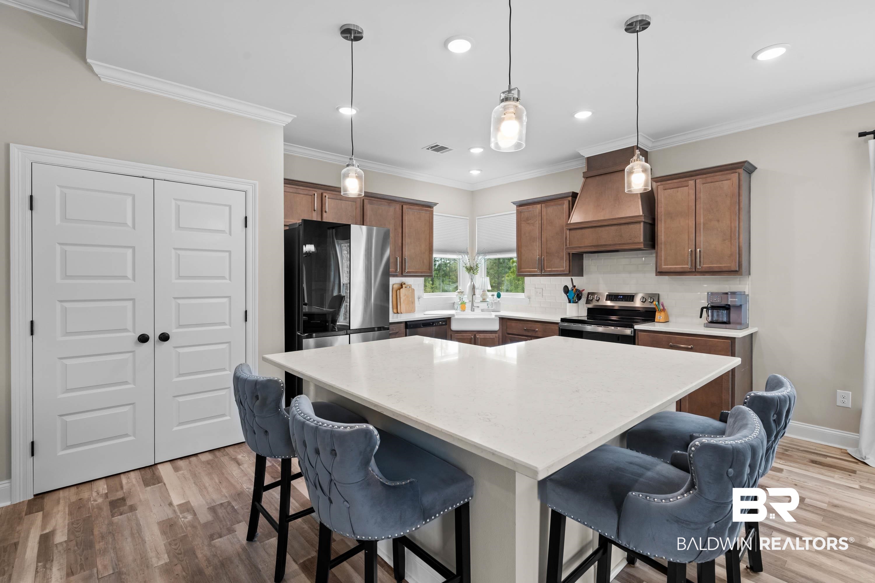 7150 Powell Road, Unit LOT 6A Eight Mile, AL 36613 - Photo 7 of 35 Kitchen featuring a breakfast bar, stainless steel appliances, crown molding, light wood-style floors, and hanging light fixtures