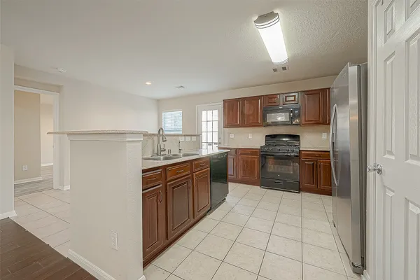 a kitchen with stainless steel appliances granite countertop a refrigerator and a sink