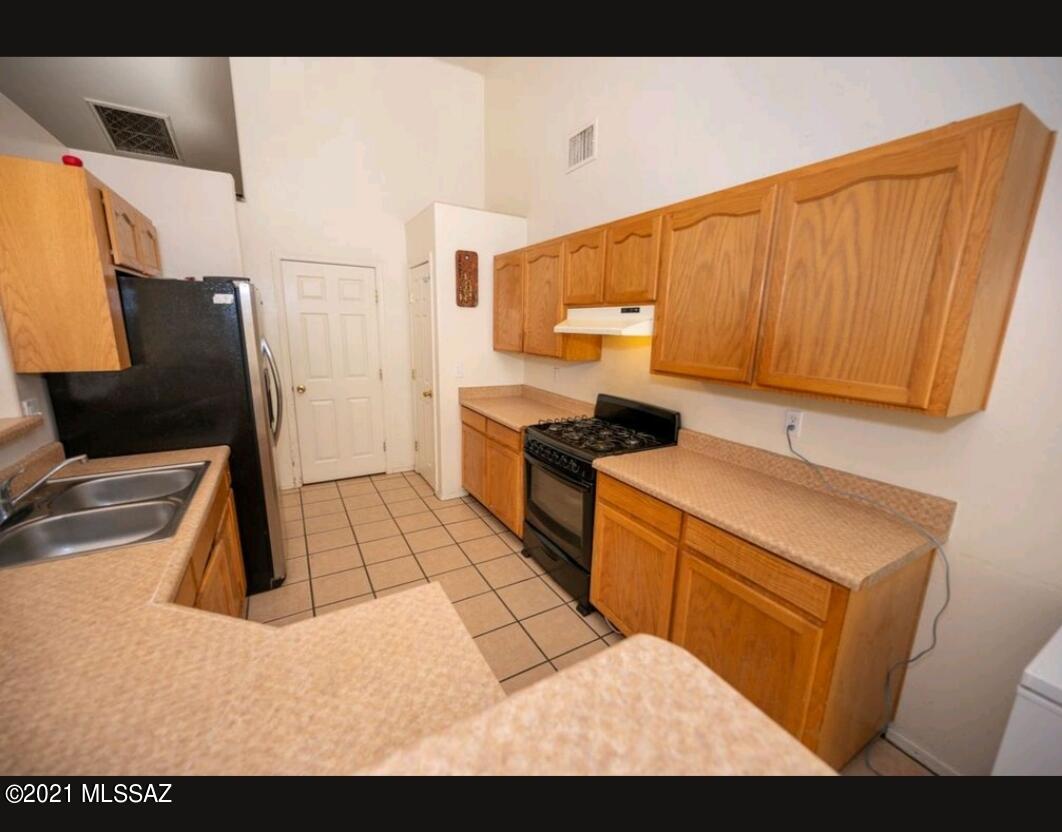 1375 Pendleton Drive Rio Rico, AZ 85648 - Photo 21 of 25 a kitchen with a sink and cabinets
