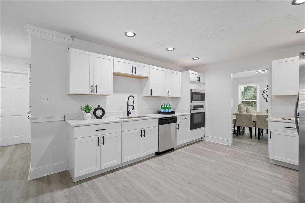 4645 Riveredge Cove Snellville, GA 30039 - Photo 12 of 43 a kitchen with white cabinets and stainless steel appliances
