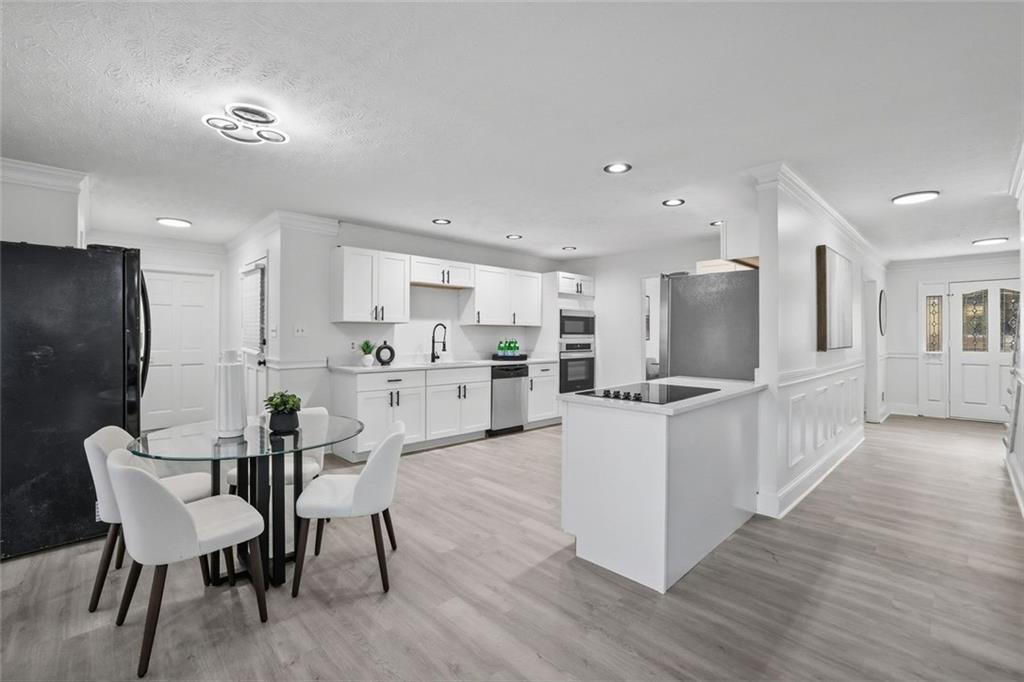 4645 Riveredge Cove Snellville, GA 30039 - Photo 13 of 43 a kitchen with stainless steel appliances kitchen island granite countertop a table chairs microwave and sink