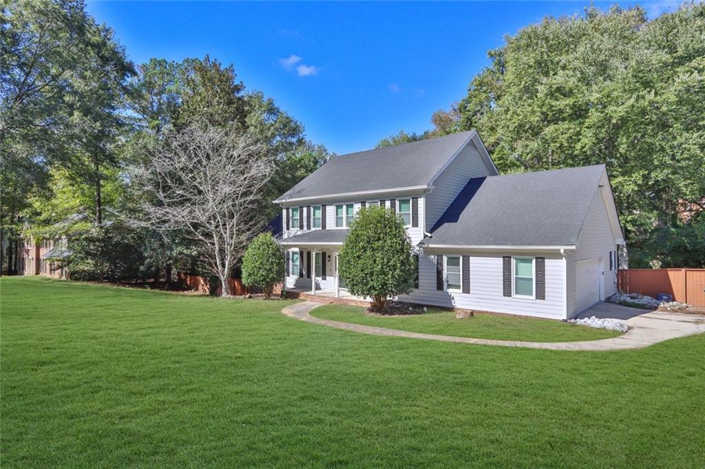 4645 Riveredge Cove Snellville, GA 30039 - Photo 2 of 43 a front view of a house with a garden and trees