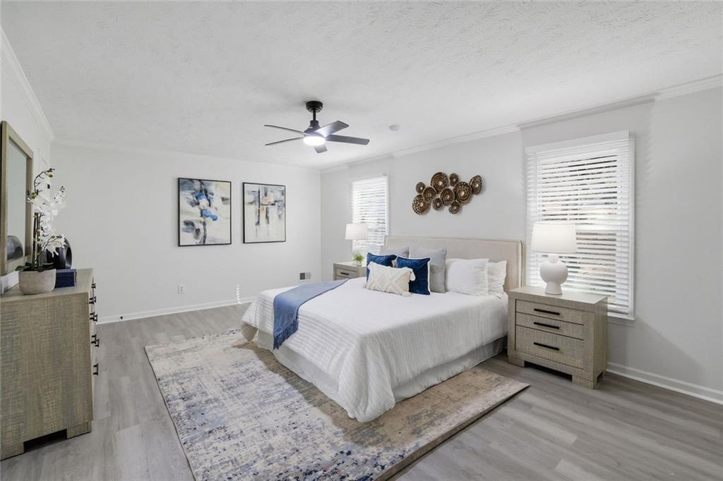 4645 Riveredge Cove Snellville, GA 30039 - Photo 22 of 43 a bedroom with a large bed and a chandelier