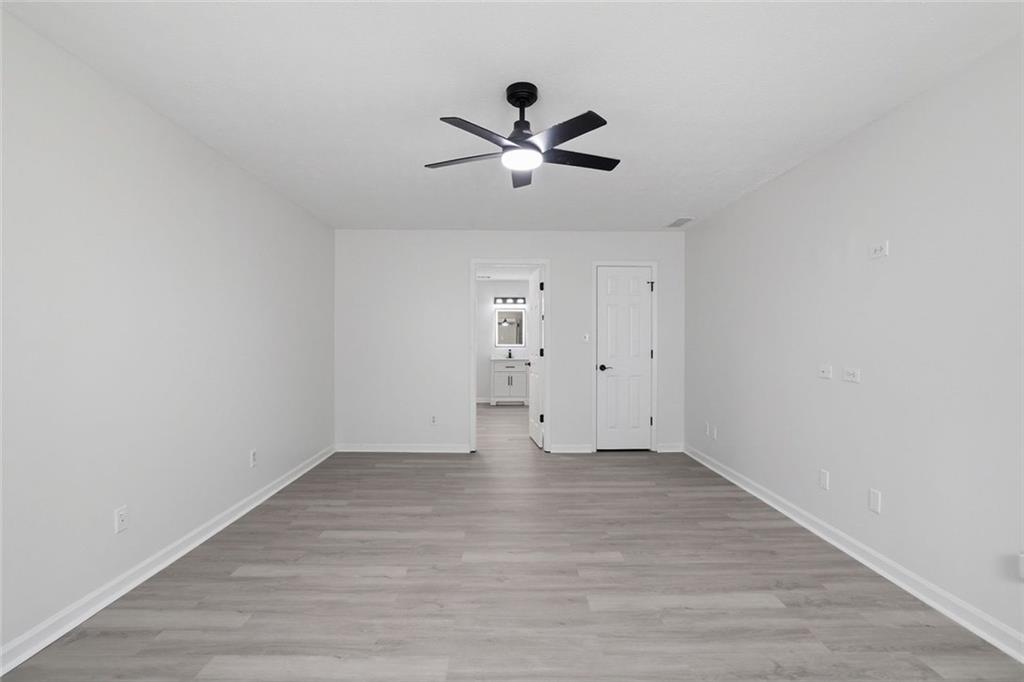 4645 Riveredge Cove Snellville, GA 30039 - Photo 26 of 43 a view of an empty room with wooden floor and a ceiling fan
