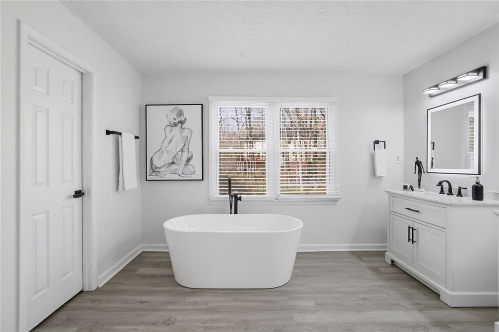 4645 Riveredge Cove Snellville, GA 30039 - Photo 29 of 43 a white bath tub sitting in a spacious bathroom next to a window