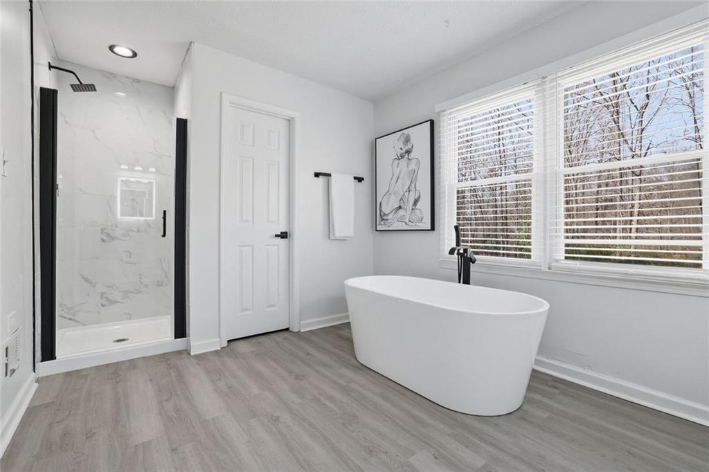 4645 Riveredge Cove Snellville, GA 30039 - Photo 32 of 43 a bathroom with a bathtub mirror and window