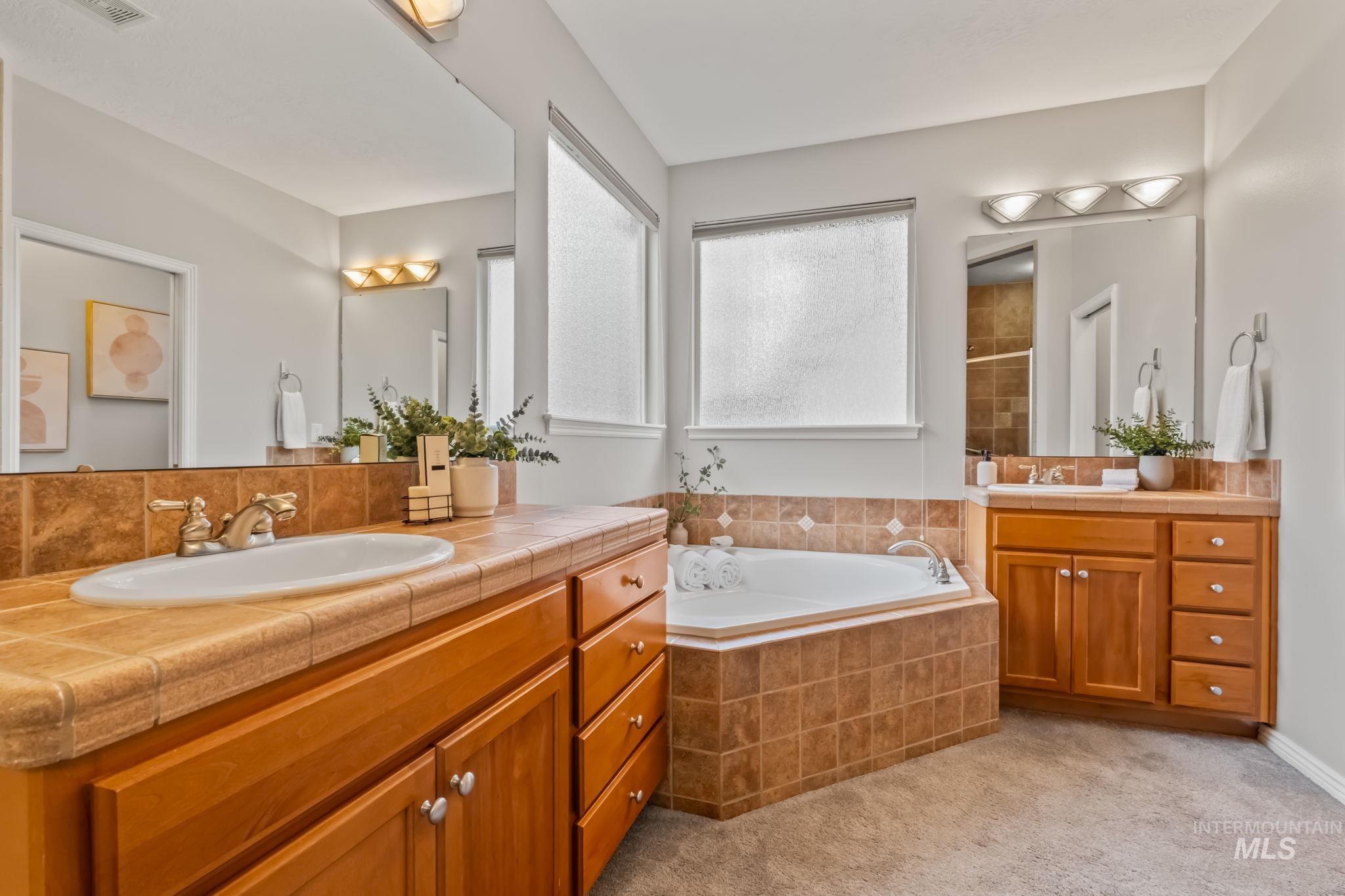 1579 North Watson Way Eagle, ID 83616 - Photo 14 of 30 Full bath featuring two vanities, a bath, light carpet, and a shower stall