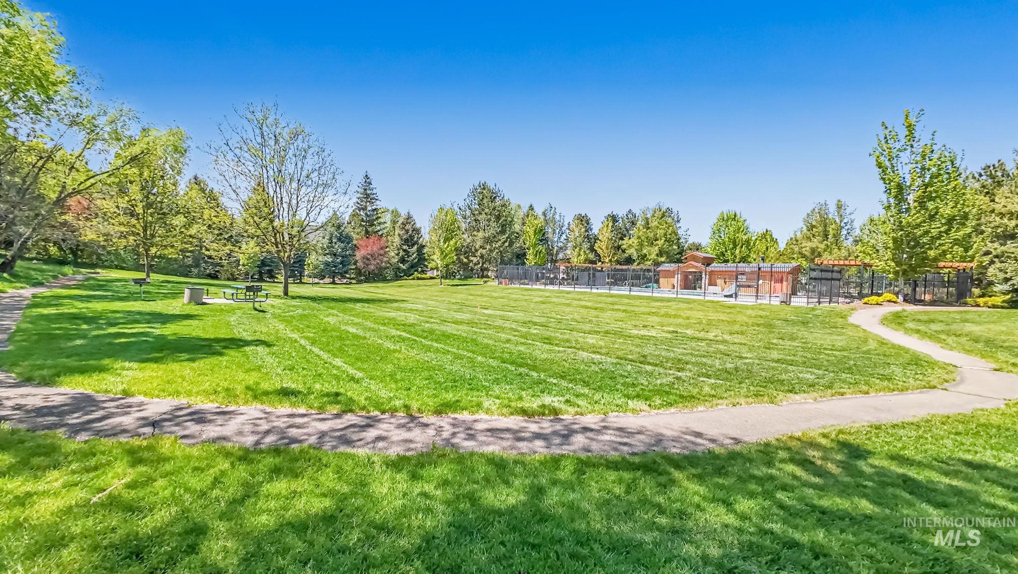 1579 North Watson Way Eagle, ID 83616 - Photo 30 of 30 Expansive green space featuring a paved walking path, mature trees, and distant recreational structures