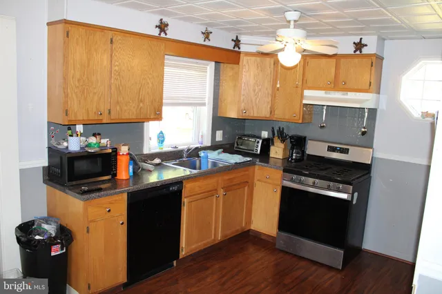 a kitchen with a sink cabinets and wooden floor