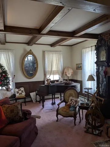 a living room with furniture a clock and a large window