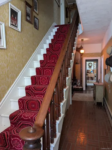 a view of staircase with lots of frames on wall and a window