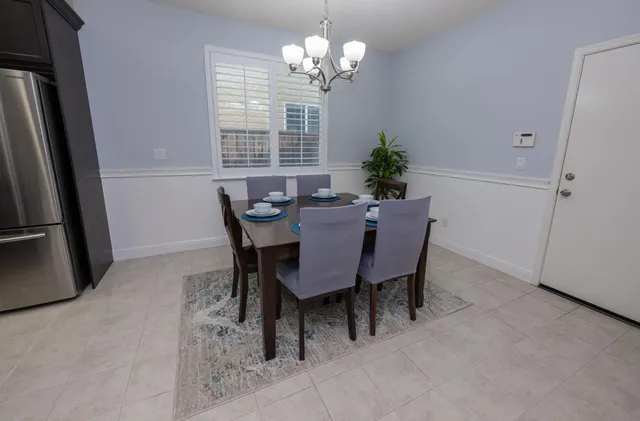 a dining room with furniture a chandelier and a window