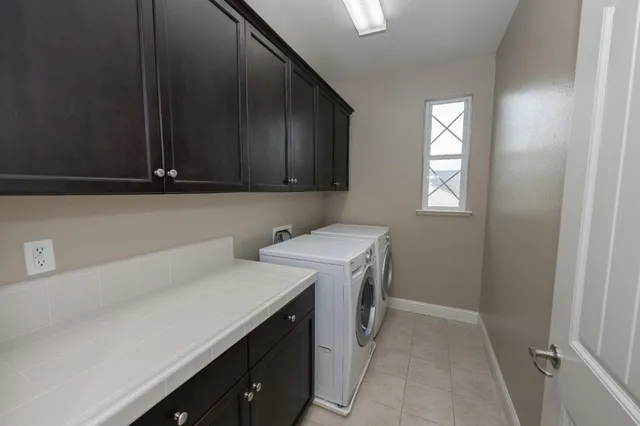 a utility room with cabinets washer and dryer