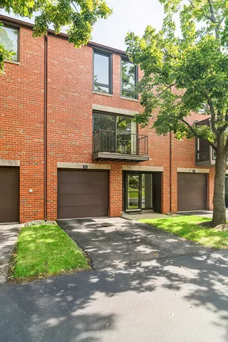 a front view of a house with a garden and trees