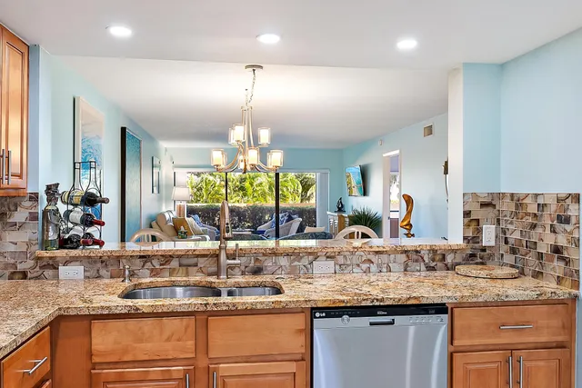 a kitchen with granite countertop kitchen island a counter space and a large window