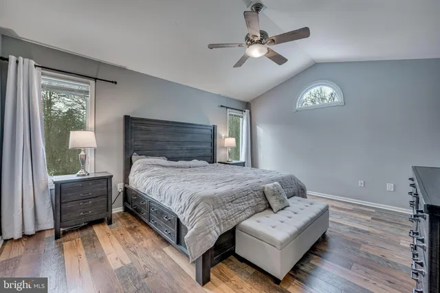 a spacious bedroom with a bed a chandelier and a window