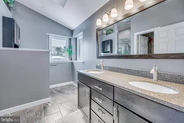 a bathroom with a granite countertop sink a mirror and a window