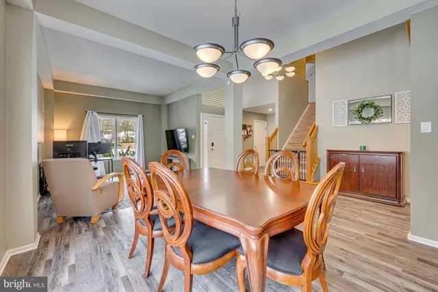 a view of a dining room with furniture a chandelier and wooden floor
