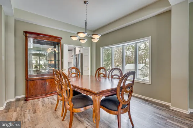 a dining room with furniture a chandelier and wooden floor