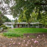 a front view of a house with a yard and trees