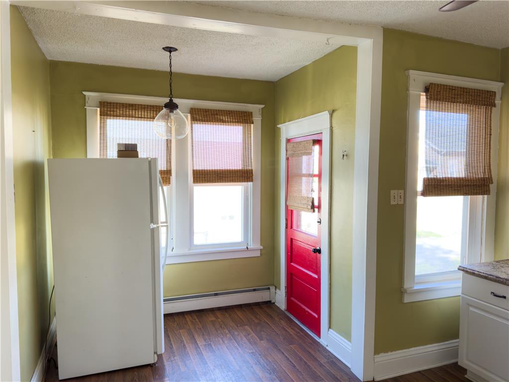 870 Chestnut Street Coplay, PA 18037 - Photo 6 of 24 A well-lit kitchen with rich wooden floors and a vibrant red entry door.