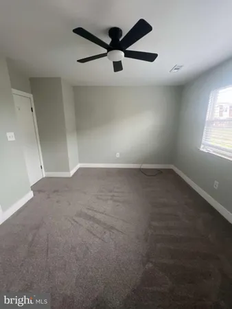 an empty room with windows and ceiling fan