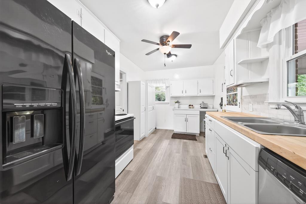 5829 Dearborn Avenue Columbus, GA 31909 - Photo 11 of 29 a kitchen with a sink dishwasher a refrigerator oven and white cabinets