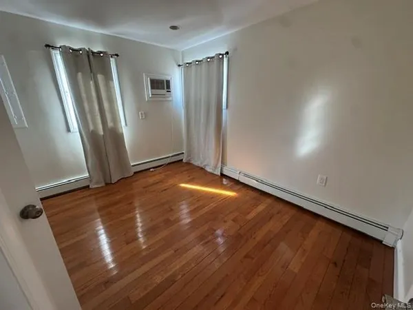 an empty room with wooden floor and a window