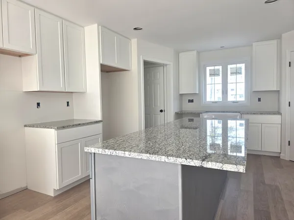 a kitchen with granite countertop white cabinets and a stainless steel appliances