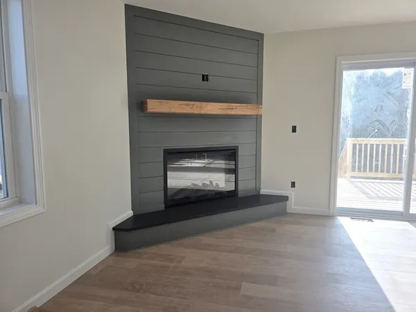 a view of an empty room with a fireplace and a window