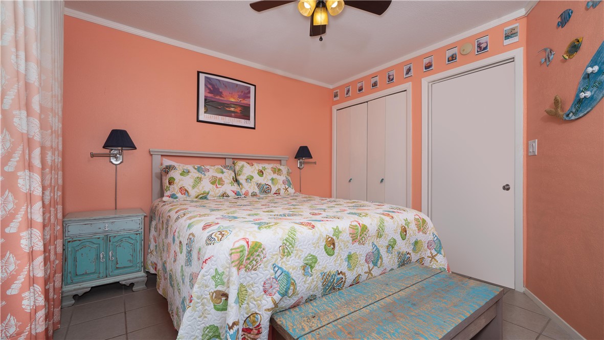 2290 North Fulton Beach Road Rockport, TX 78382 - Photo 20 of 26 a bedroom with a bed and a chandelier