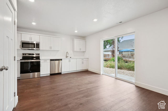 1615 North Angel Street, Unit F Layton, UT 84041 - Photo 4 of 45 Kitchen with appliances with stainless steel finishes, light countertops, white cabinetry, dark wood finished floors, and recessed lighting