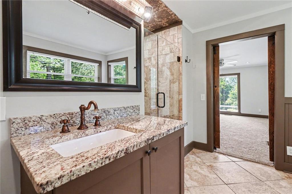 450 Big Springs Road Southeast Calhoun, GA 30701 - Photo 17 of 39 a bathroom with a granite countertop sink a mirror and a shower