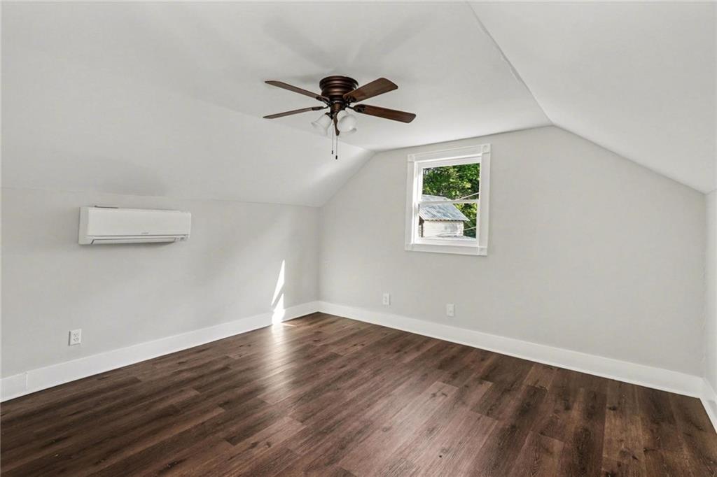 450 Big Springs Road Southeast Calhoun, GA 30701 - Photo 30 of 39 an empty room with wooden floor a ceiling fan and windows