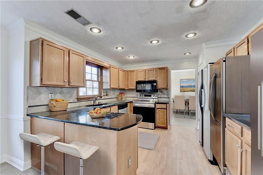 3945 Genoa Court Duluth, GA 30096 - Photo 21 of 64 a kitchen with stainless steel appliances granite countertop a refrigerator stove top oven and sink