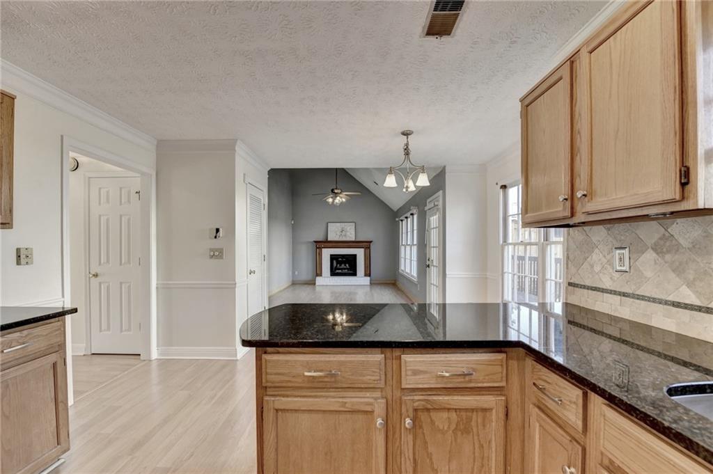 3945 Genoa Court Duluth, GA 30096 - Photo 25 of 64 a kitchen with granite countertop a sink and a stove top oven