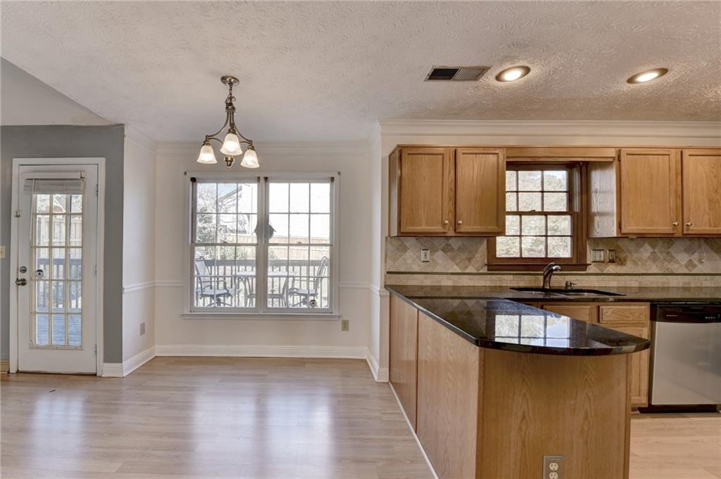 3945 Genoa Court Duluth, GA 30096 - Photo 26 of 64 a kitchen with stainless steel appliances granite countertop a stove a sink and a wooden floors